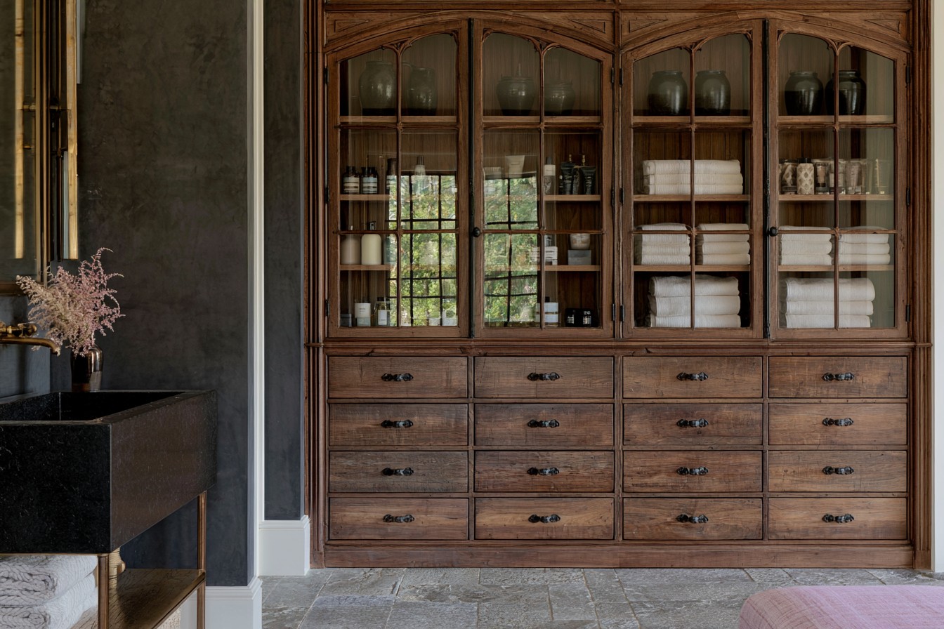 Antique apothecary-style storage cabinet in a Gothic bathroom