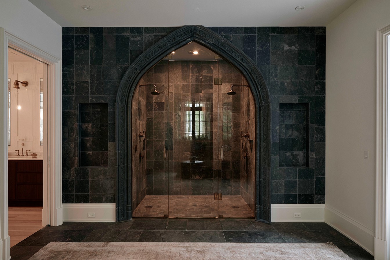 Cathedral-inspired arched shower in a dramatic Gothic bathroom