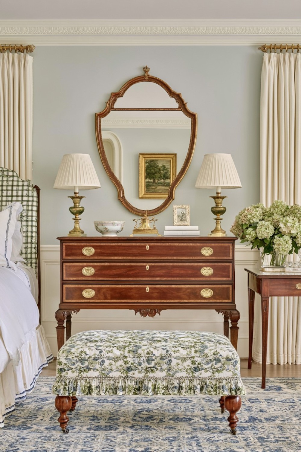 Federal-style mirror displayed above an antique bedroom chest