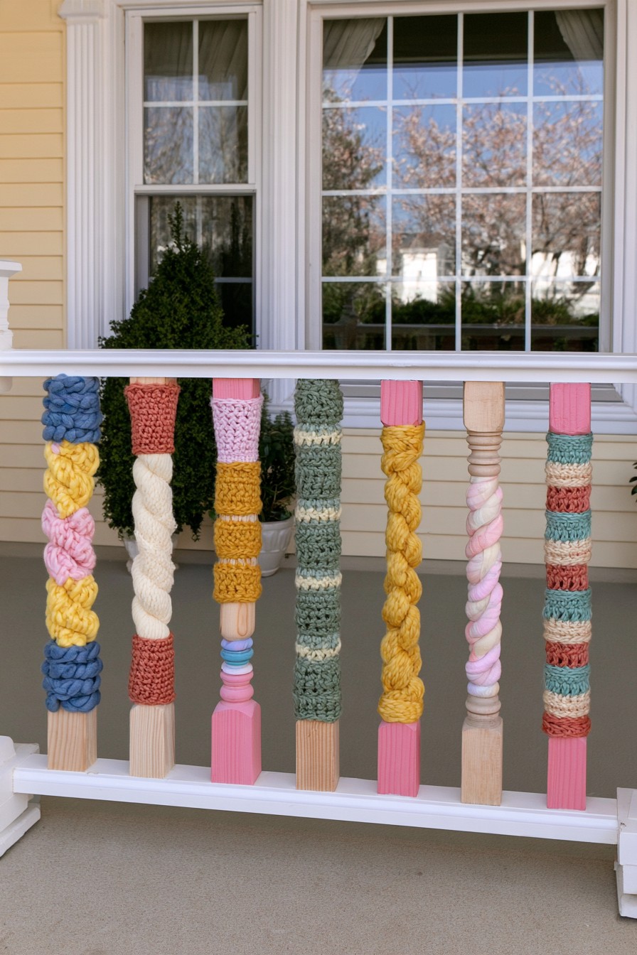 Porch railing decorated with colorful yarn wraps and crochet sleeves