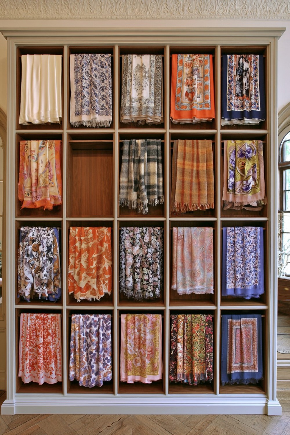 Folded scarves organized in narrow boutique display shelves