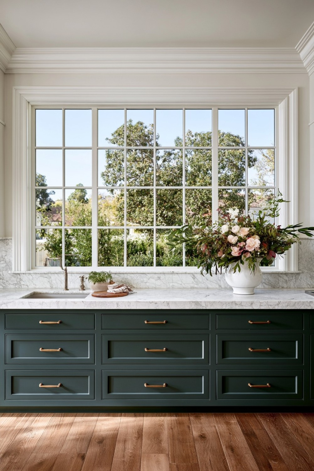 Low kitchen cabinets and worktop fitted beneath a window