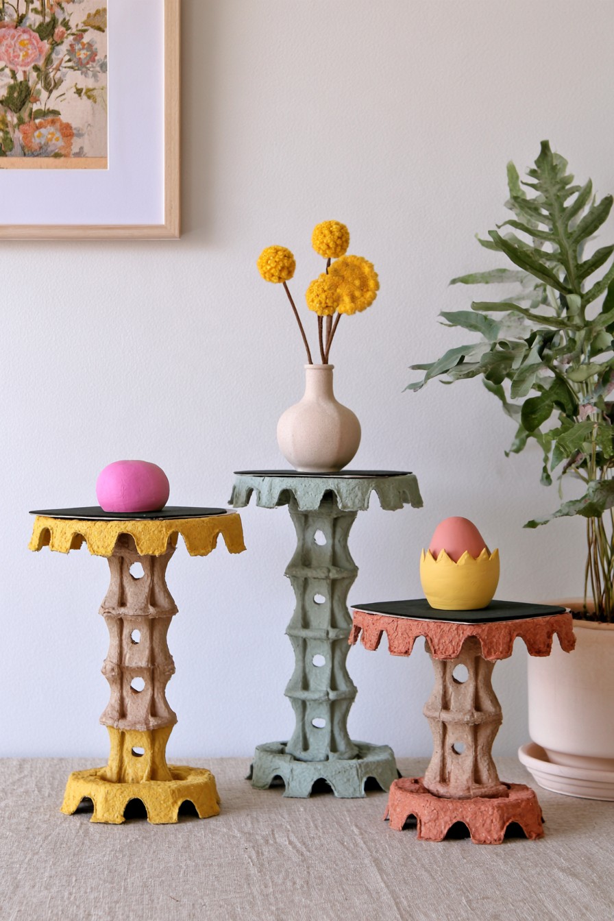 Small pedestal display stands created with stacked painted egg carton sections