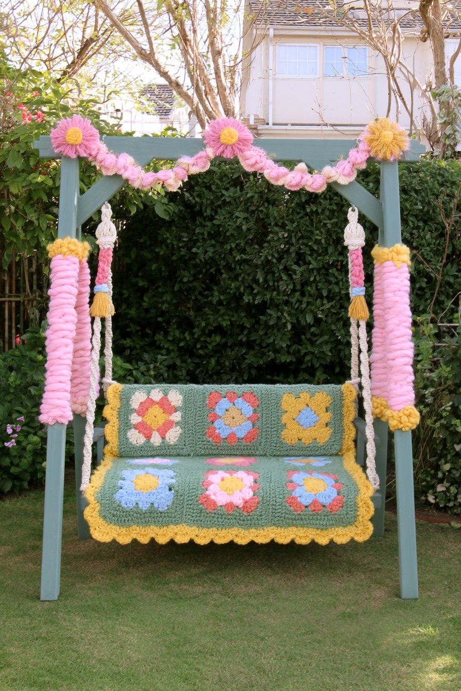 Garden swing decorated with removable floral crochet panels