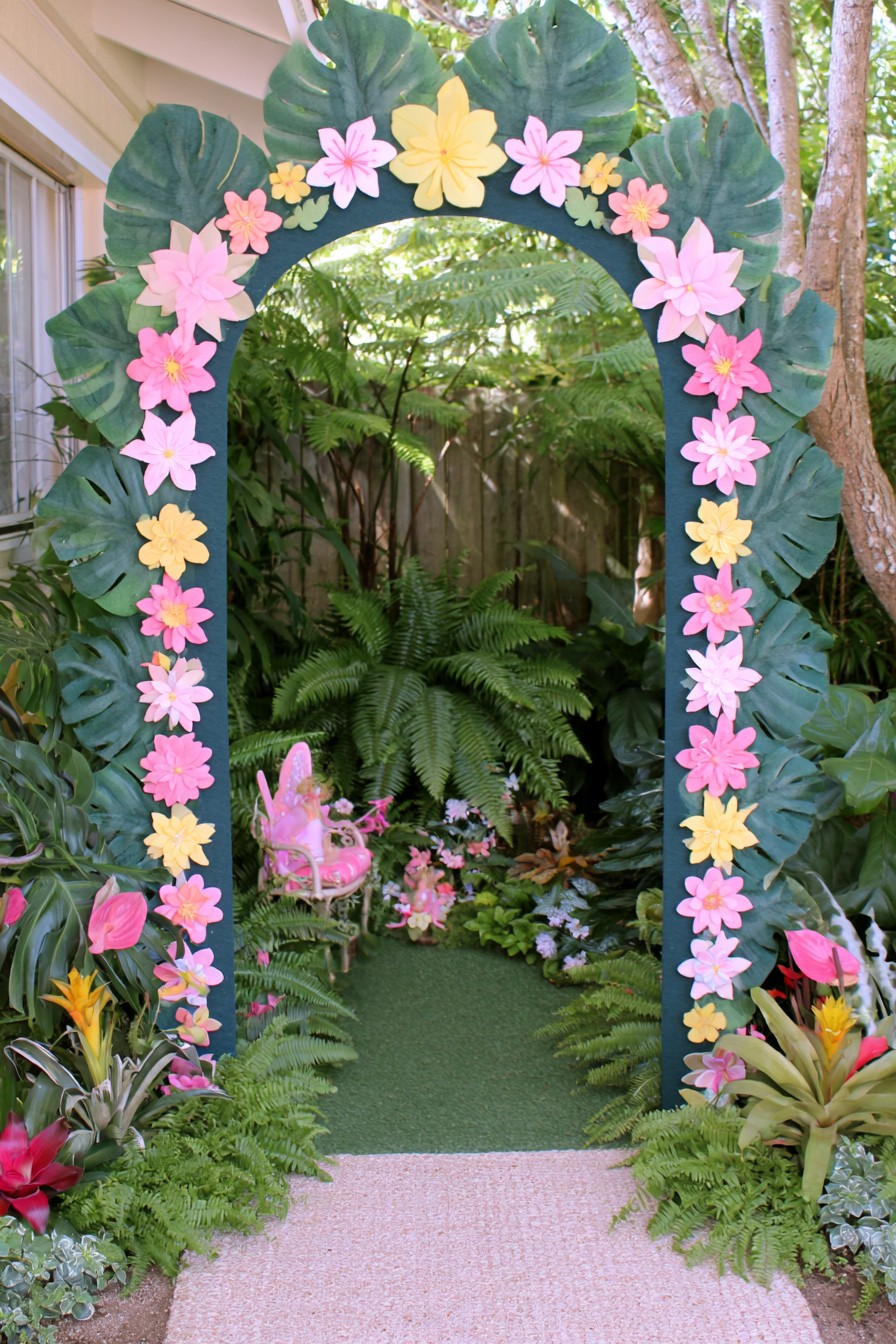 Tropical flower arch forming an entrance to a lush fairy garden