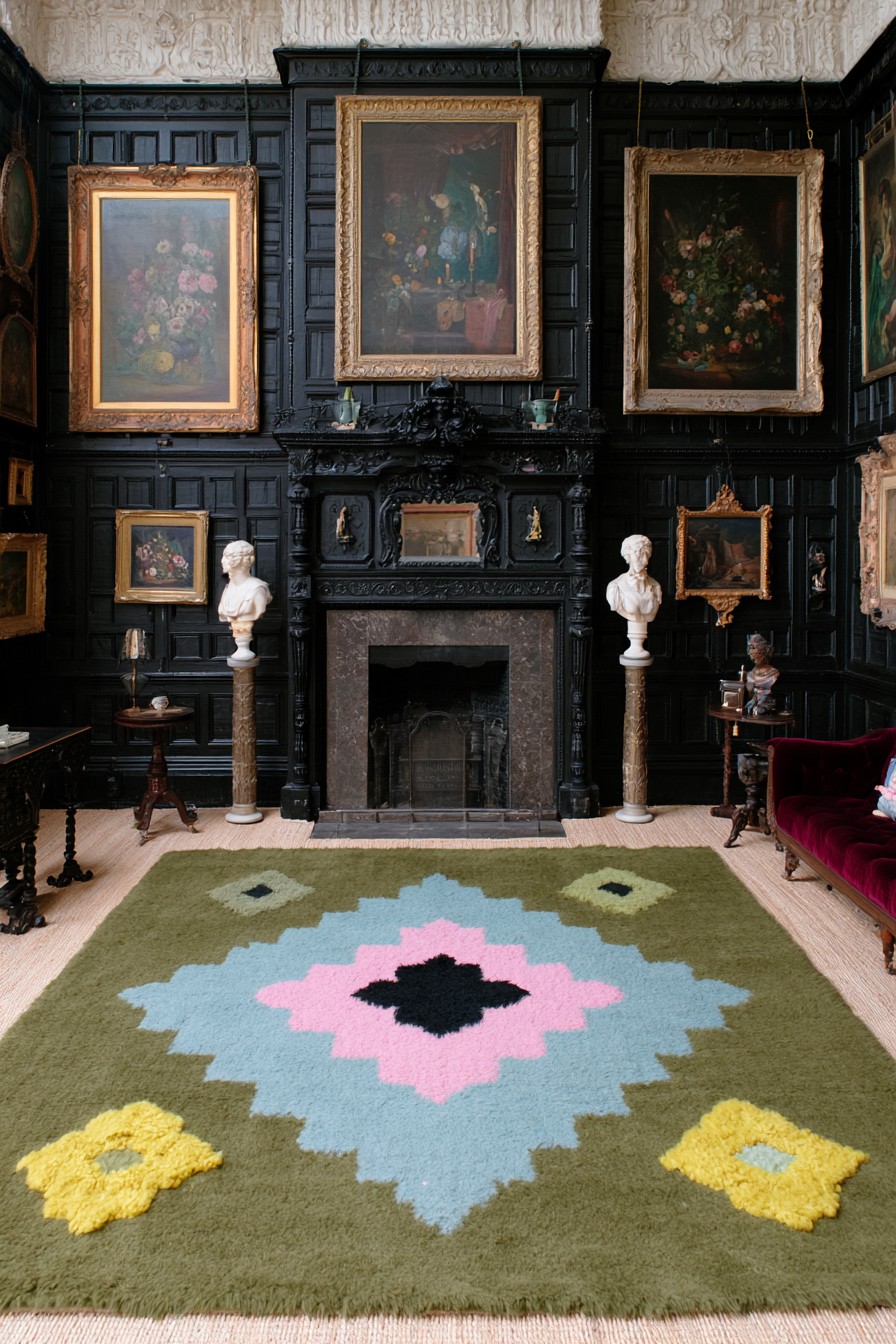 Black paneled fireplace wall with large gilt framed floral paintings and two white busts on pedestals