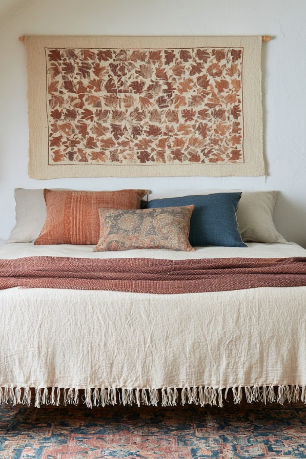 Layered bohemian attic bedroom with textiles and handcrafted decor