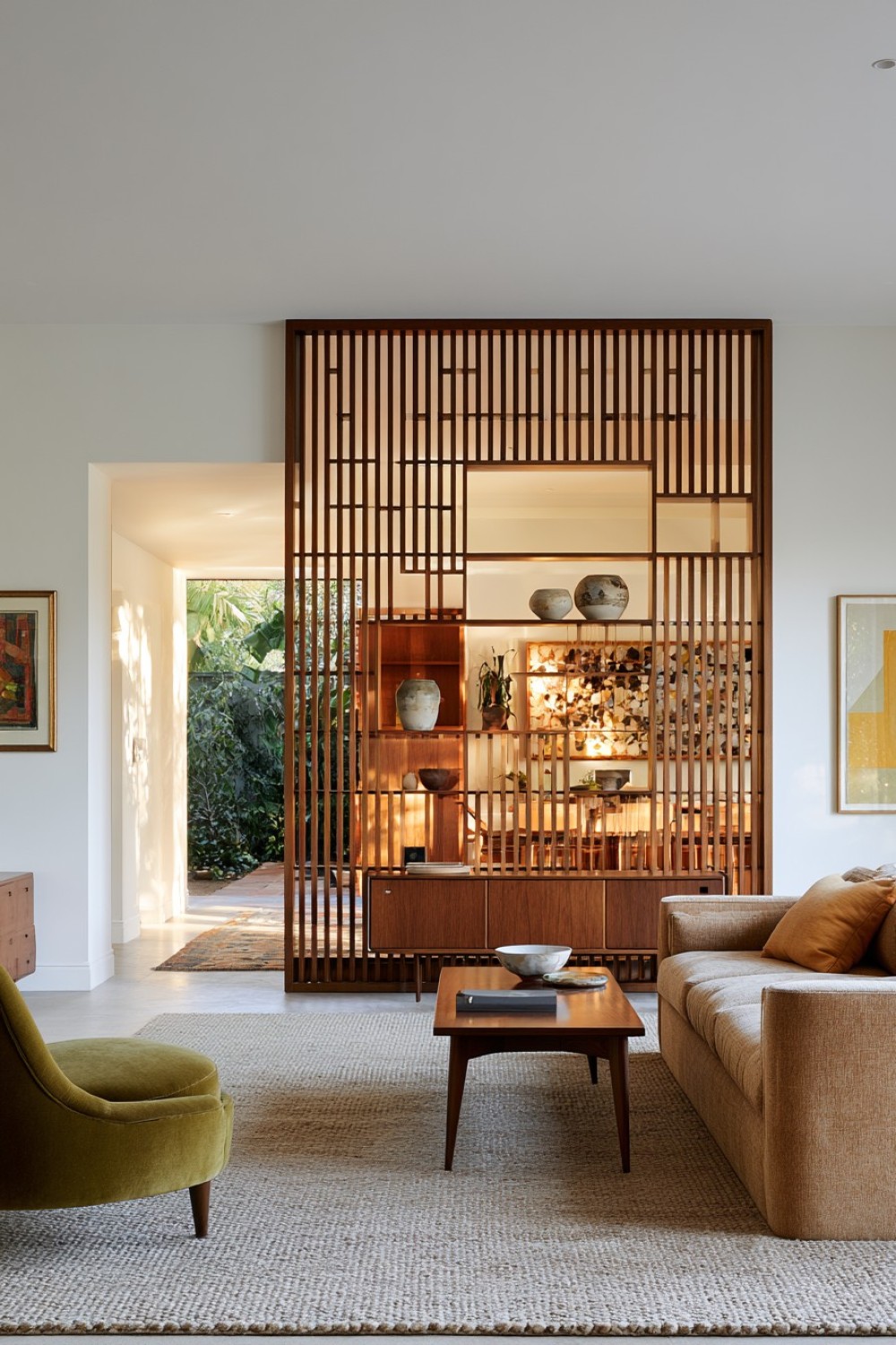 Freestanding walnut divider defining a mid-century open living room
