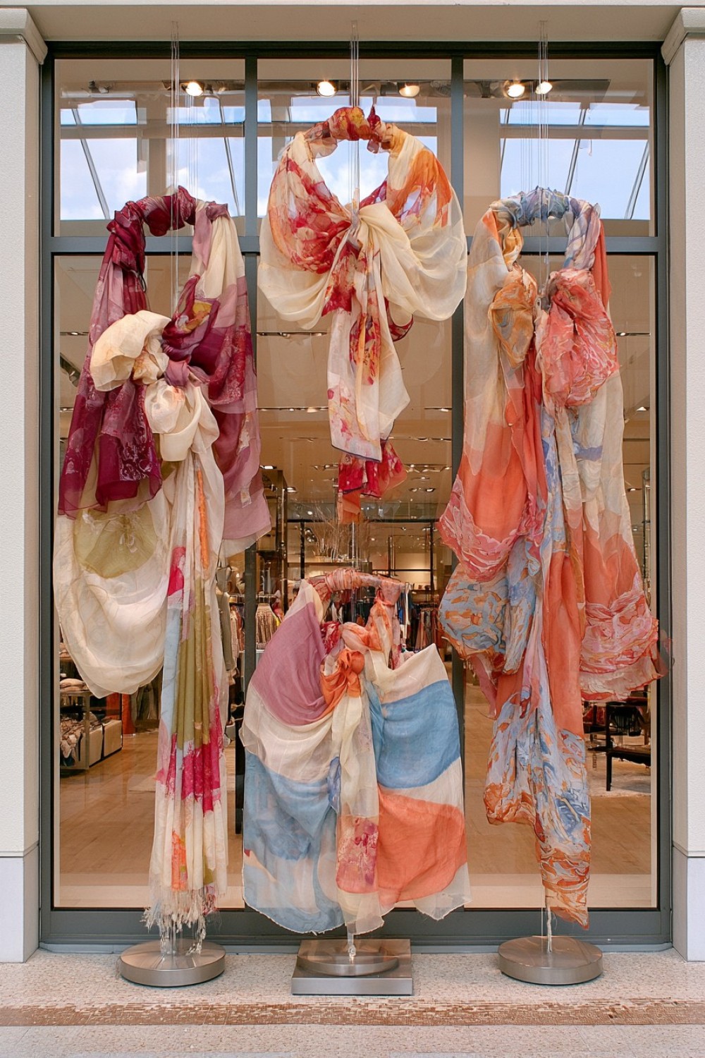 Suspended scarves forming a flowing boutique window display