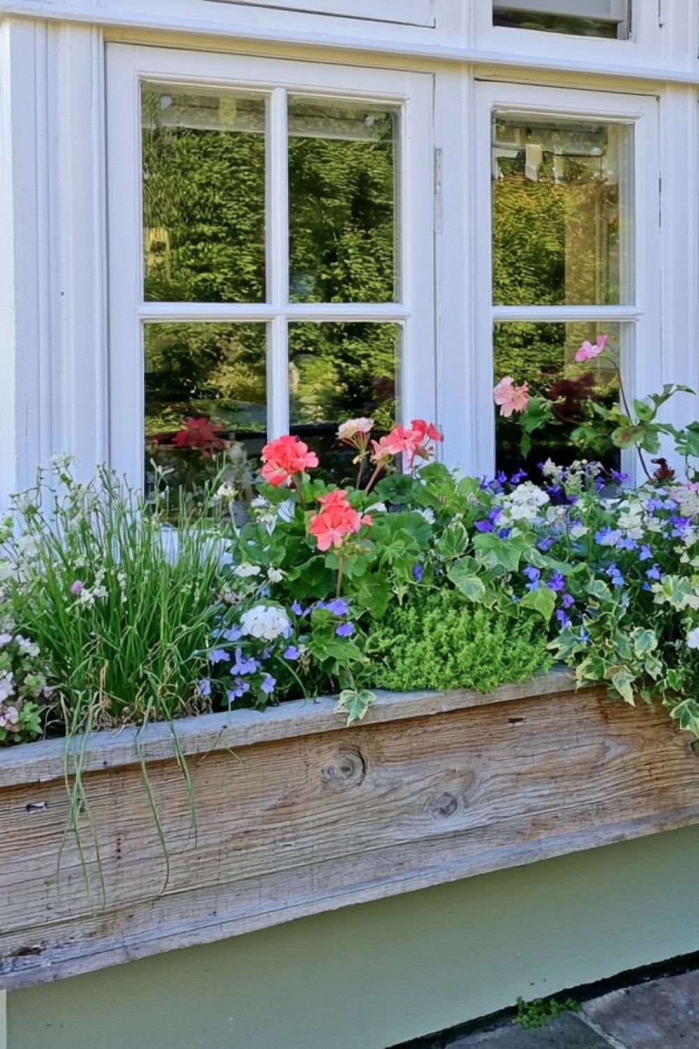 Rustic wooden flower box secured safely inside a balcony railing