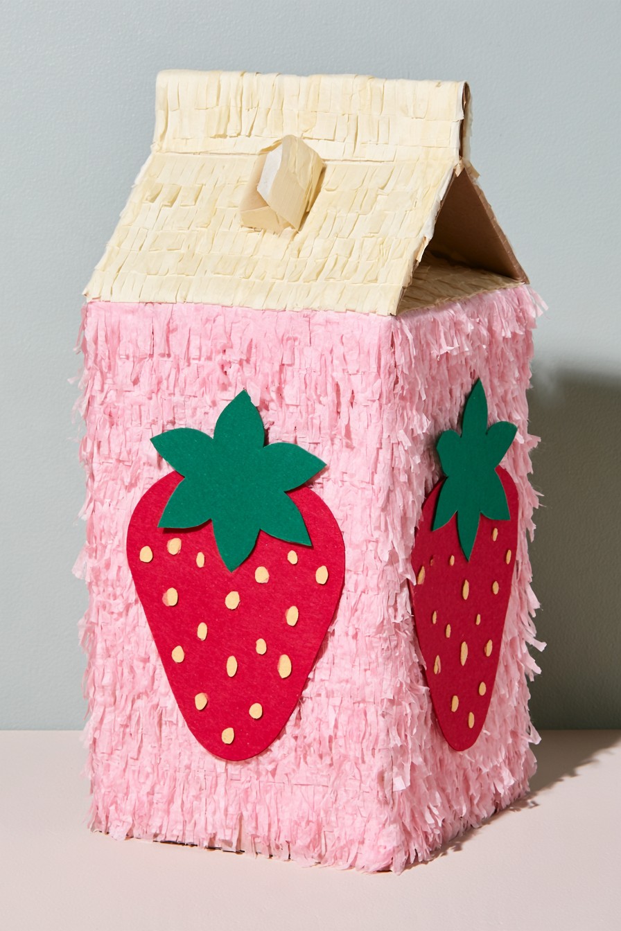 Pink strawberry milk carton piñata with paper fruit decorations