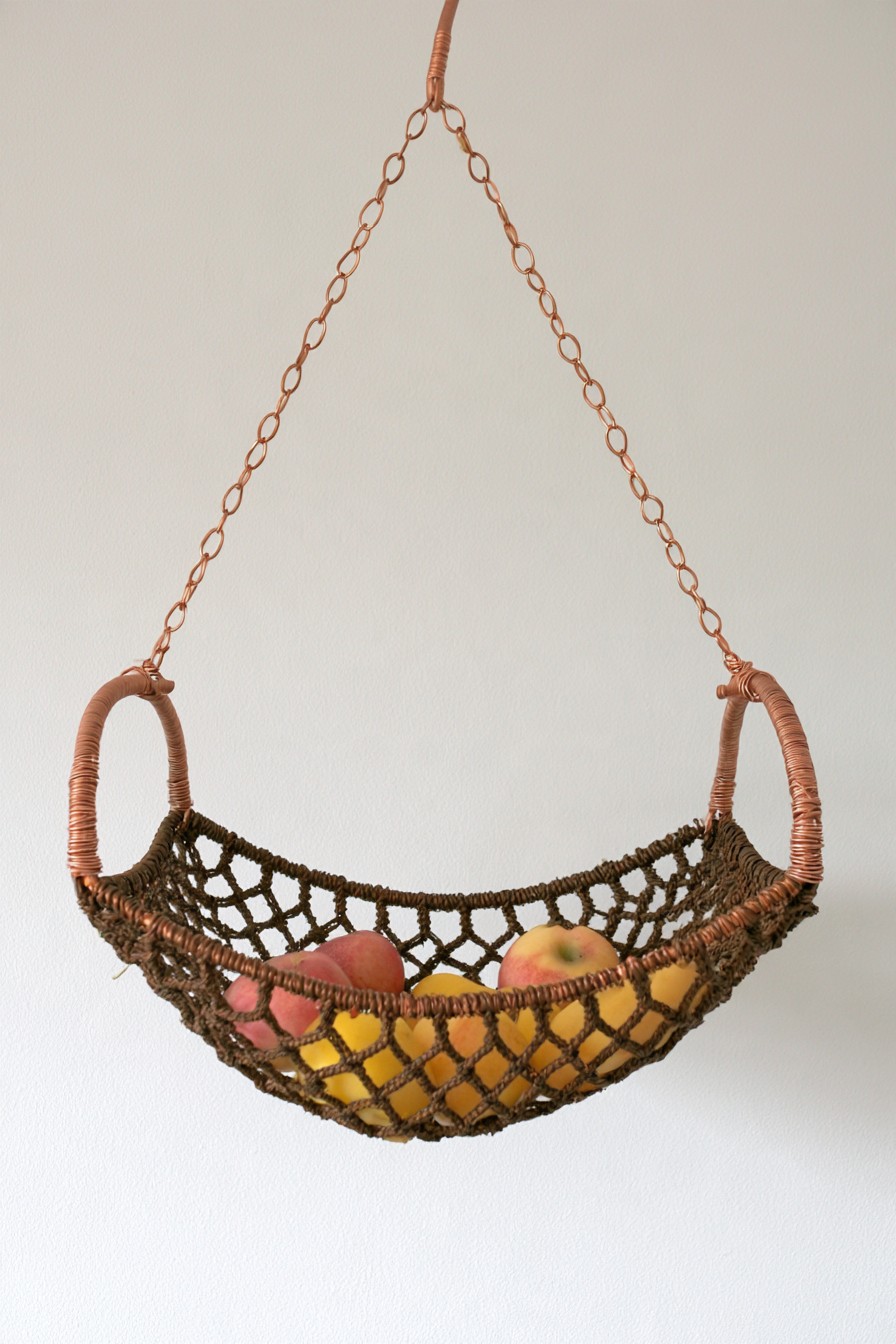 Hanging copper wire fruit basket with woven dark netting