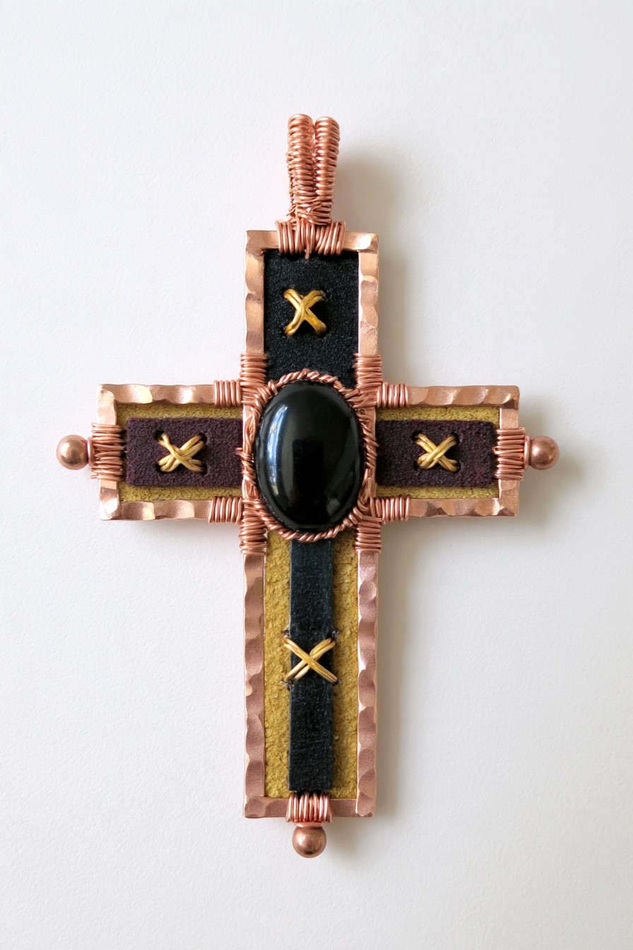 Structured copper cross with textile inlays and black stone