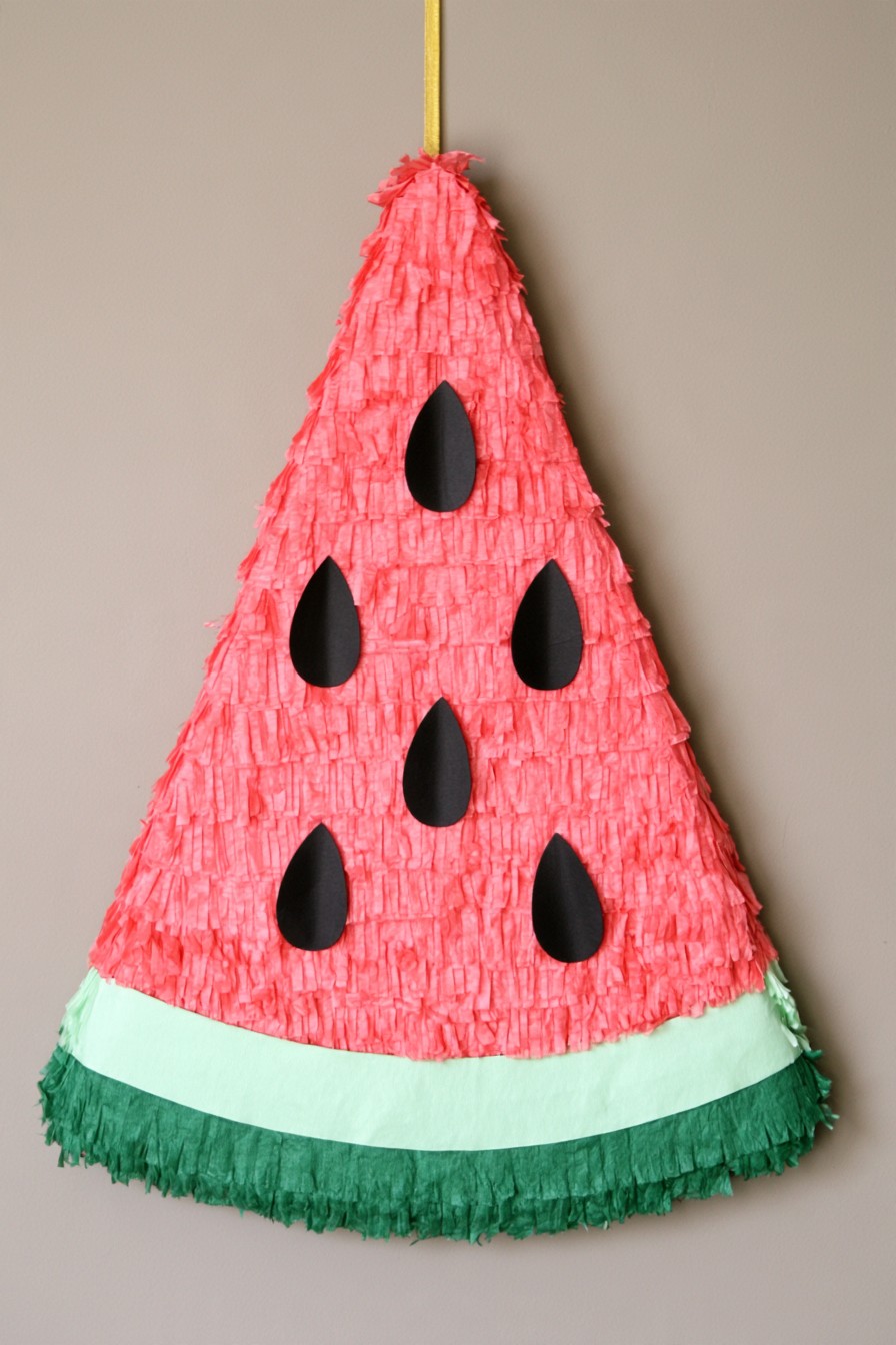 Watermelon slice piñata with red fringe green rind and black seeds