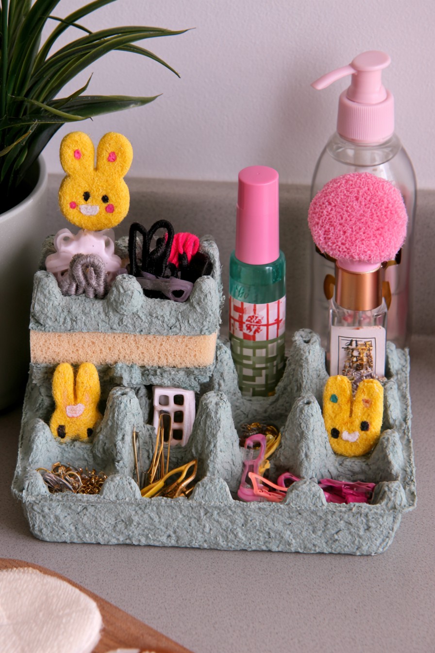 Vanity organizer with small accessories arranged in egg carton compartments