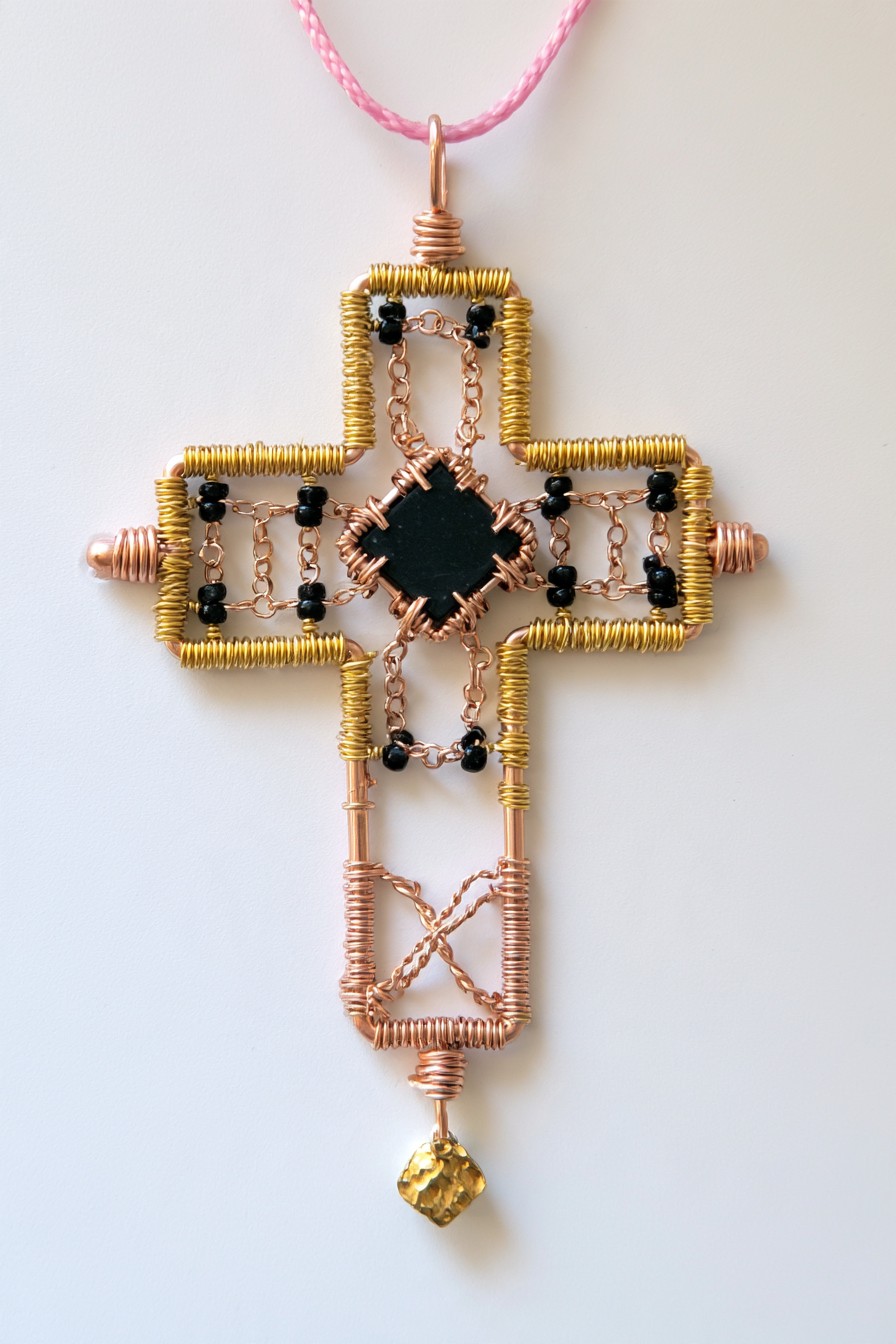 Open-frame wire cross with chain and black bead details