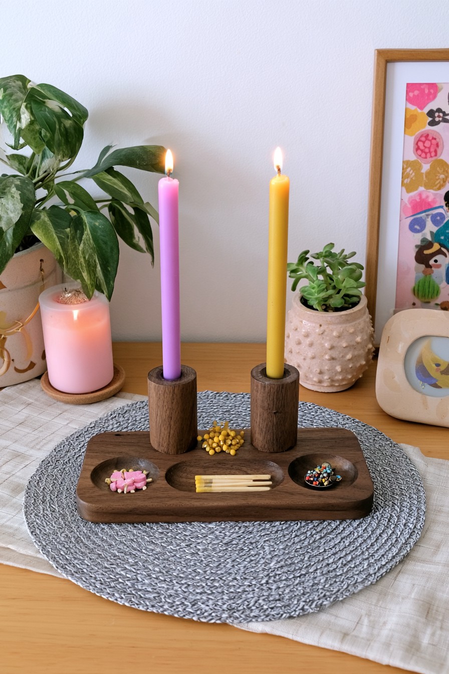 Wooden centerpiece tray with two burning taper candles and shallow decorative compartments