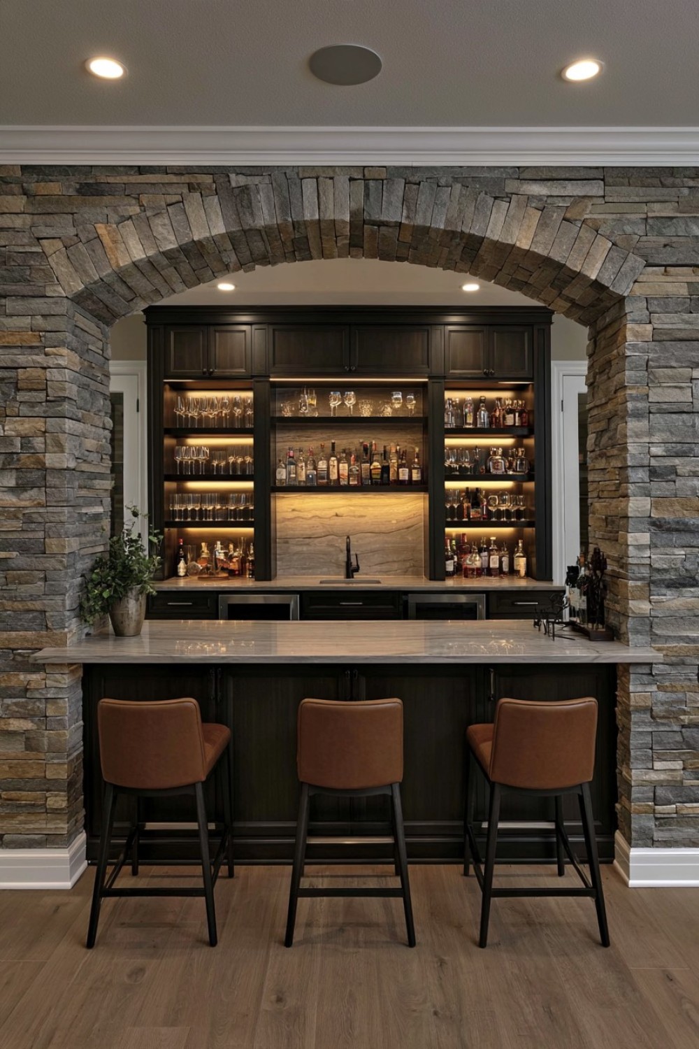 Basement bar recessed within a shallow stone arch