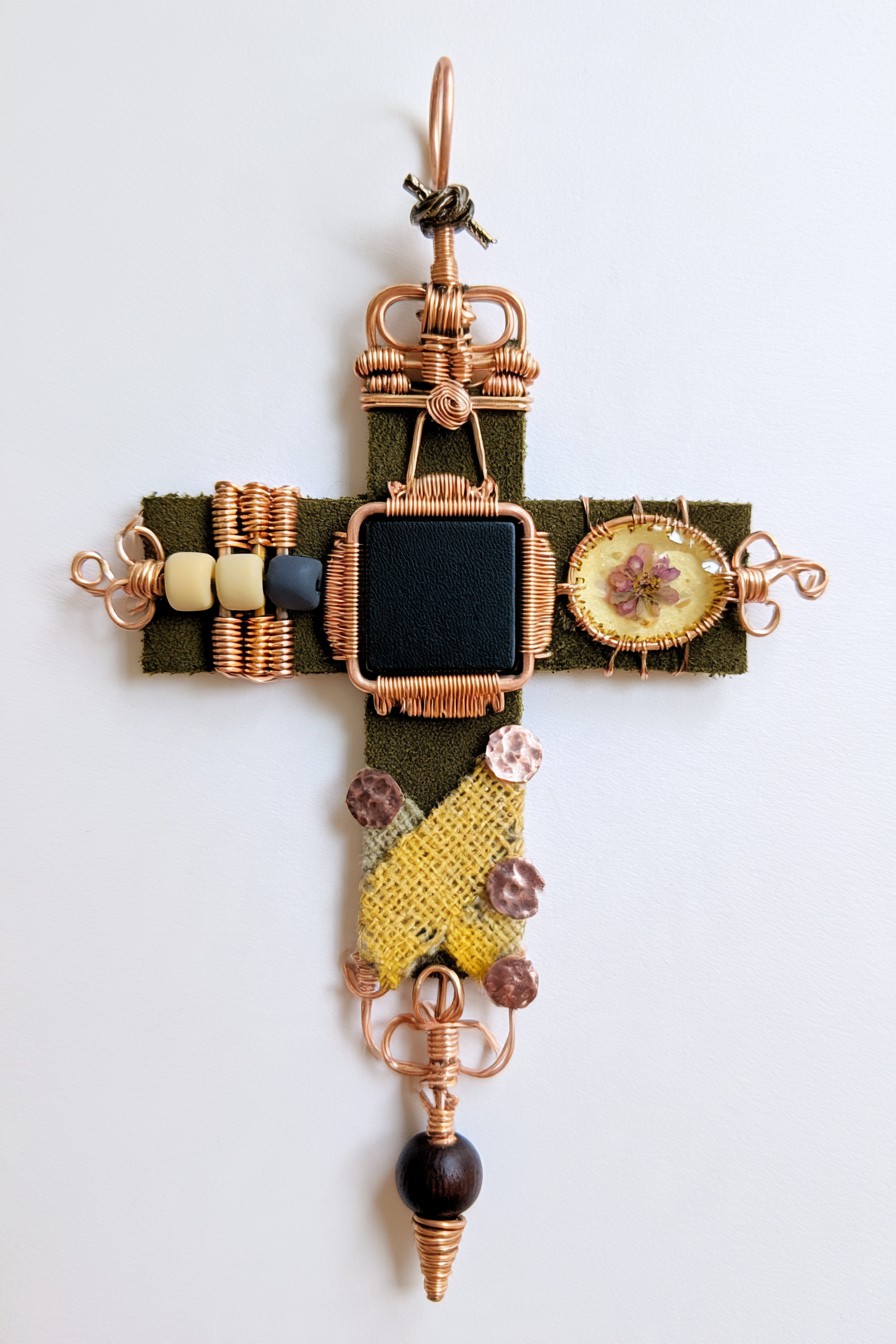 Rustic copper cross with fabric, beads, and botanical detail