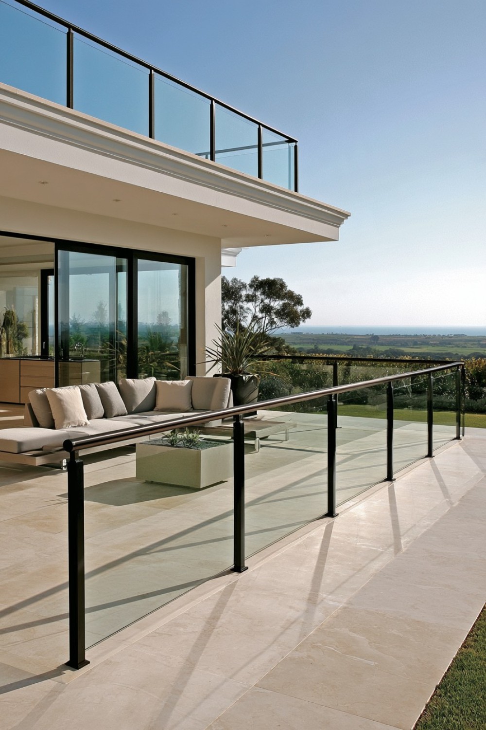 Clear glass balcony railing supported by a minimal metal frame