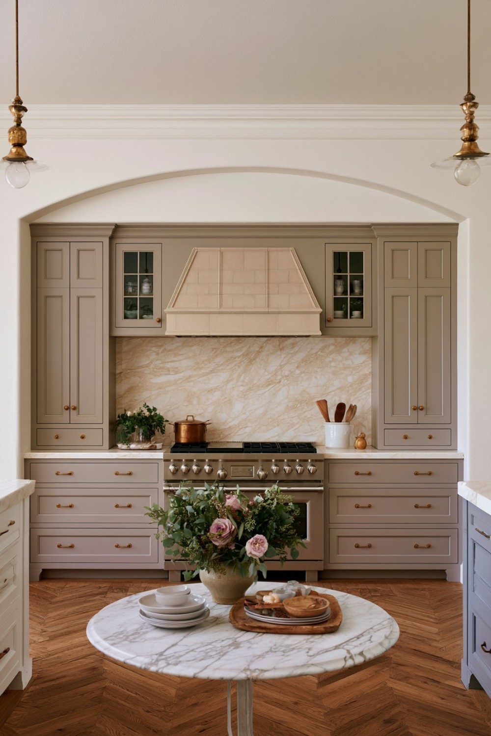 Kitchen cabinetry framing a cooking range and ventilation hood