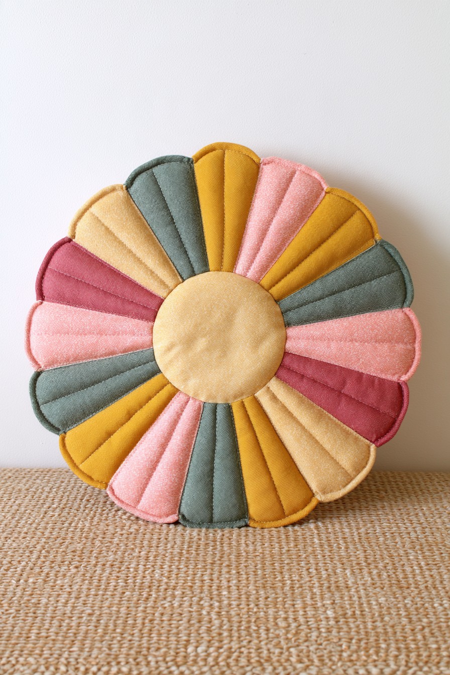 Patchwork flower pillow with multicolored quilted petals