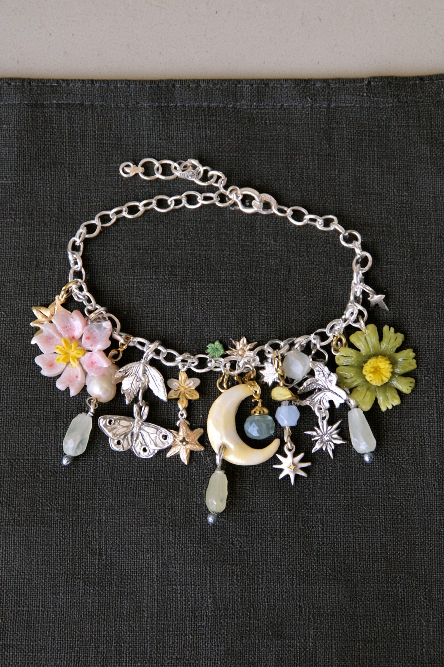 Moon garden charm bracelet with crescent moon stars moth flowers leaves and pearls