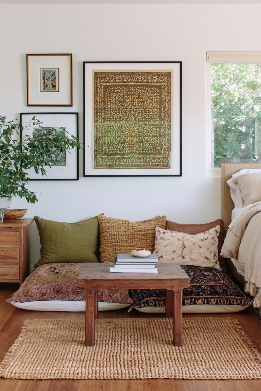 Bohemian bedroom reading corner with floor cushions beside the bed