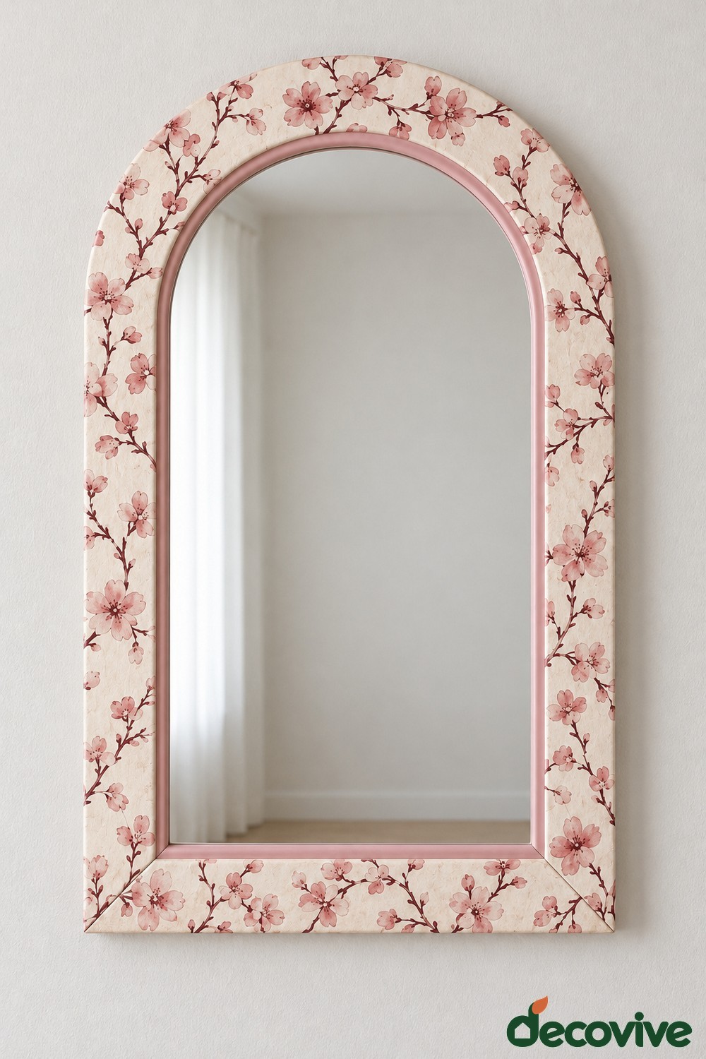Cream arched mirror frame covered in pink blossom branches with a pink inner rim