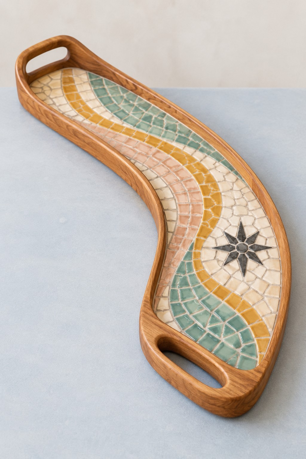 Curved wooden tray with cream, mint and mustard mosaic waves and a black star motif