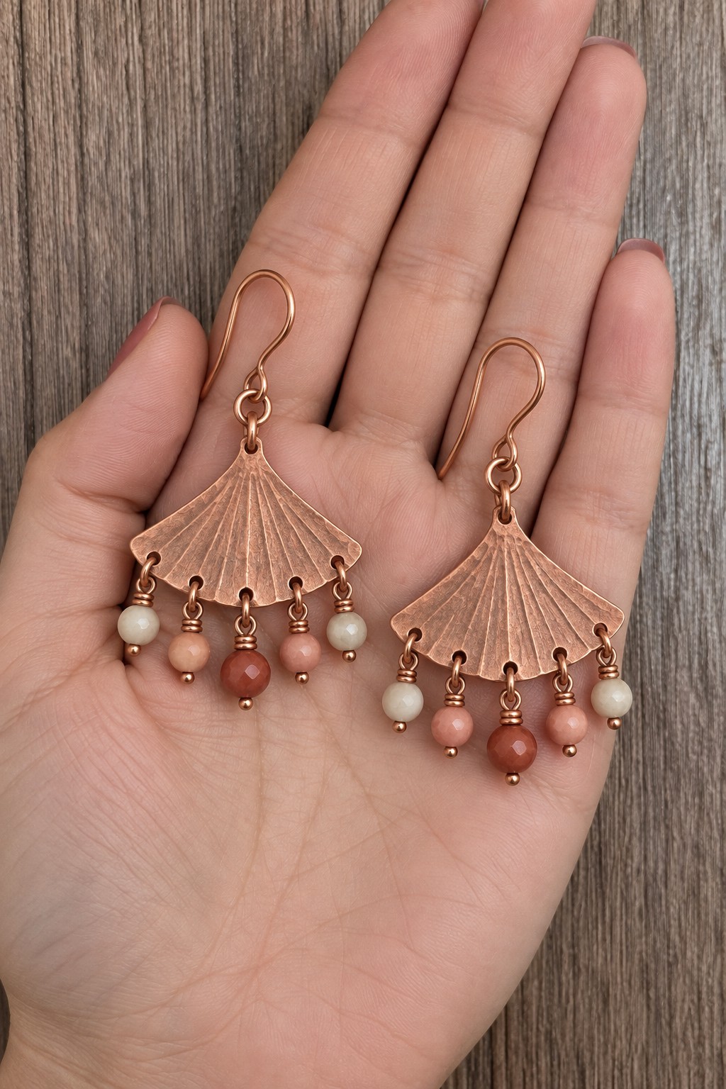 Pair of copper fan earrings with radiating lines and five pale and coral bead drops each