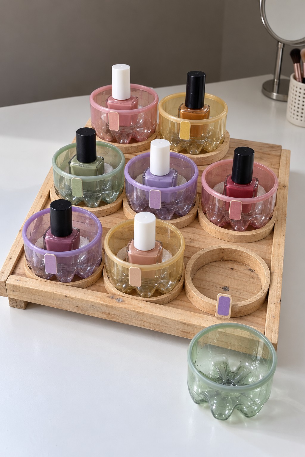 Wooden nail polish tray with pastel tinted cups made from plastic bottle bases and one removable green cup