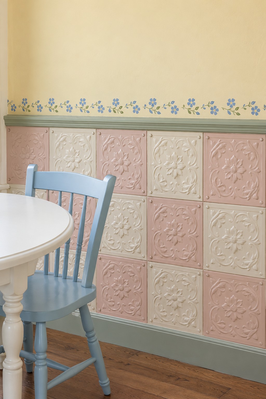 Alternating pink and cream embossed floral wall panels beneath a yellow wall with a small blue flower border