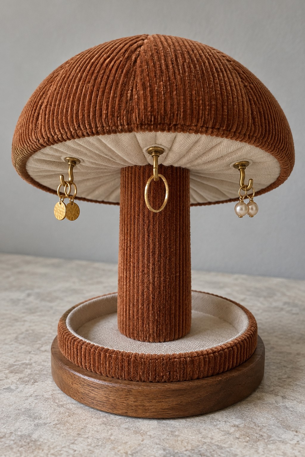 Rust corduroy mushroom jewelry stand with hooks beneath the cap and a round base