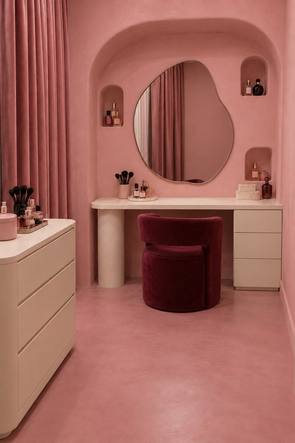 Clay pink vanity room with a rounded recess, small display niches, irregular mirror, ivory desk, and burgundy chair