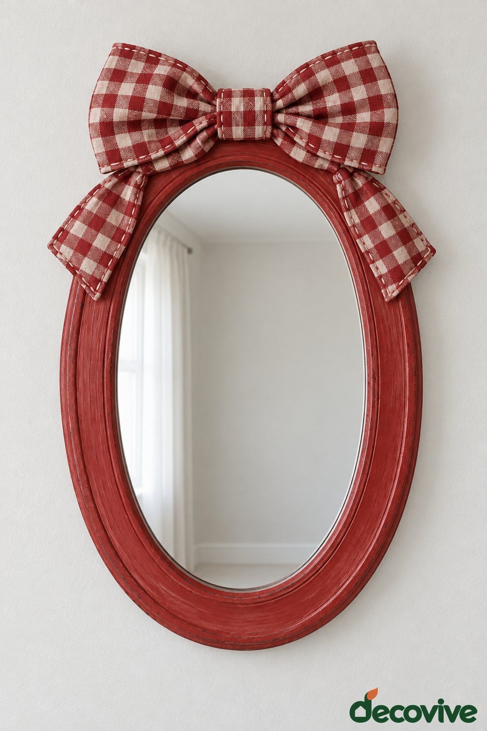 Red oval mirror topped with a large red and cream gingham fabric bow