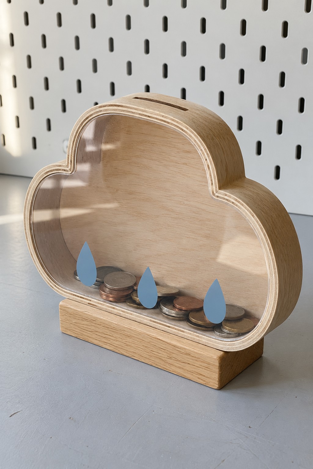 Cloud shaped wooden coin bank with a clear front, blue raindrops and rectangular stand