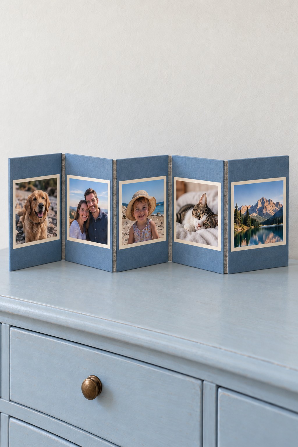 Five blue photo panels joined with cream fabric hinges and standing in an accordion shape