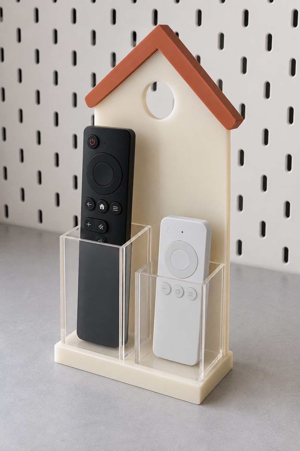 Cream acrylic house remote organizer with two clear pockets and a terracotta roof