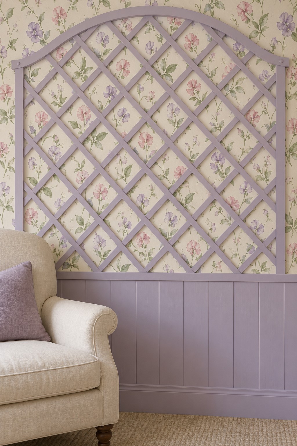 Lavender arched lattice panel over delicate floral wallpaper beside a cream armchair
