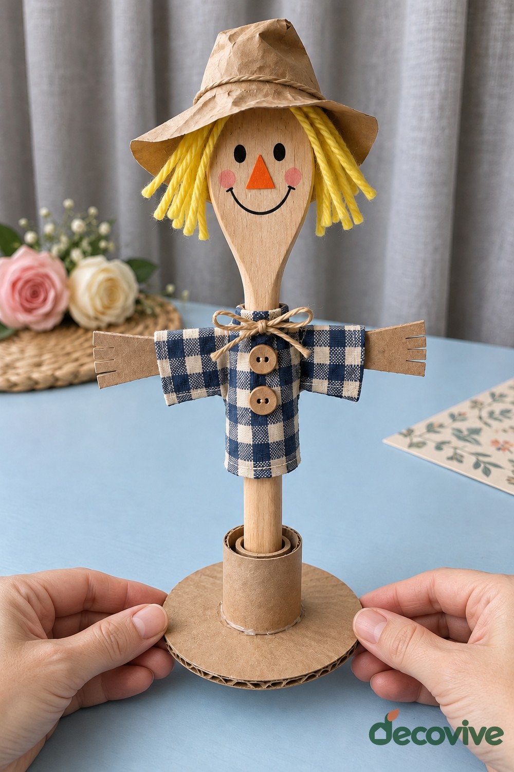Finished wooden spoon scarecrow on a cardboard stand