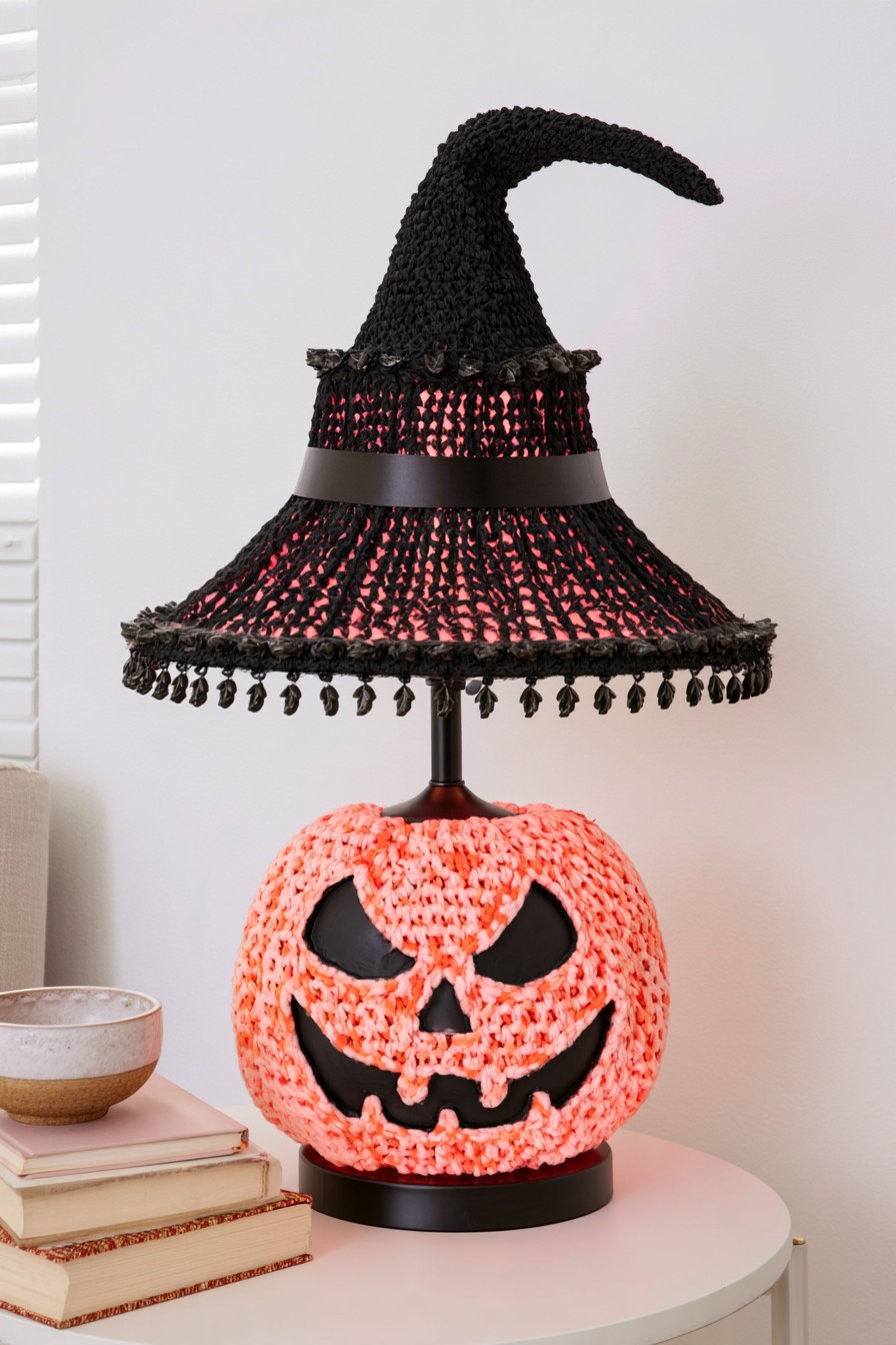 Orange knit-textured pumpkin lamp base beneath a black witch-hat-shaped shade