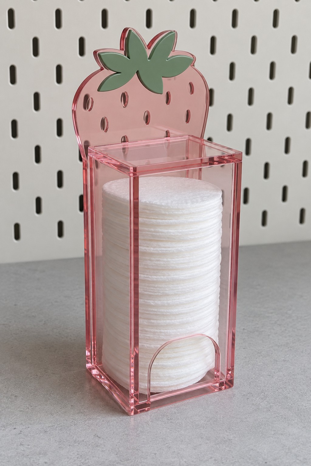 Pink strawberry acrylic cotton pad dispenser with a clear column and lower access opening