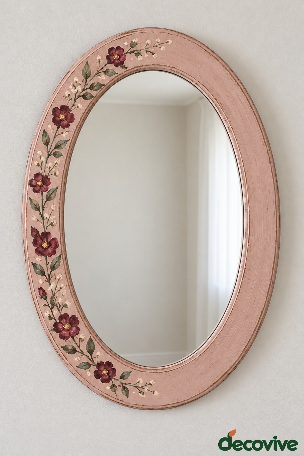 Dusty pink oval mirror with burgundy flowers and green stems painted along the left side