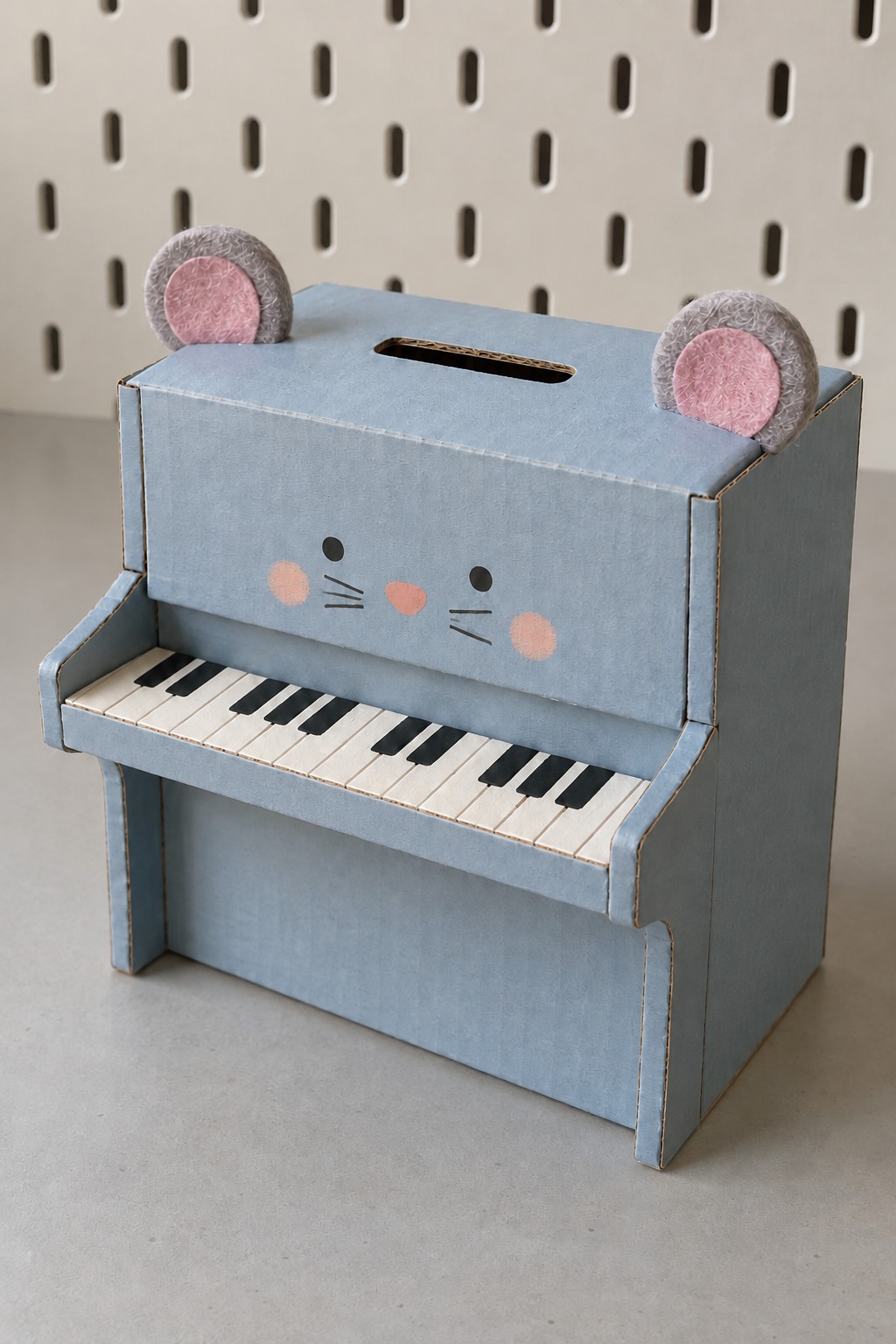 Blue miniature upright piano coin bank with mouse ears, a painted keyboard and a slot on top