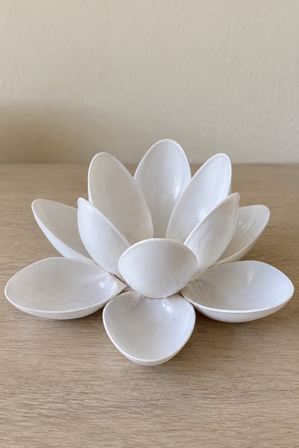 White lotus shaped tabletop sculpture assembled from overlapping spoon bowls