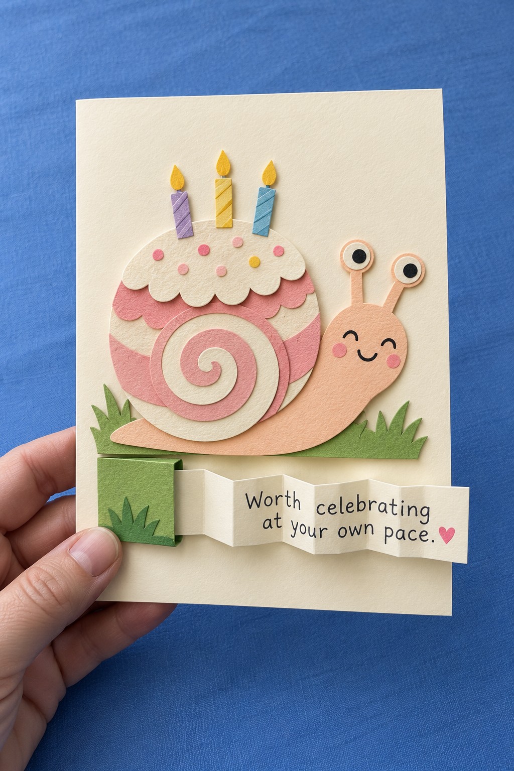 Pink snail birthday card with a cake shell and a folded message extending from a green paper pocket