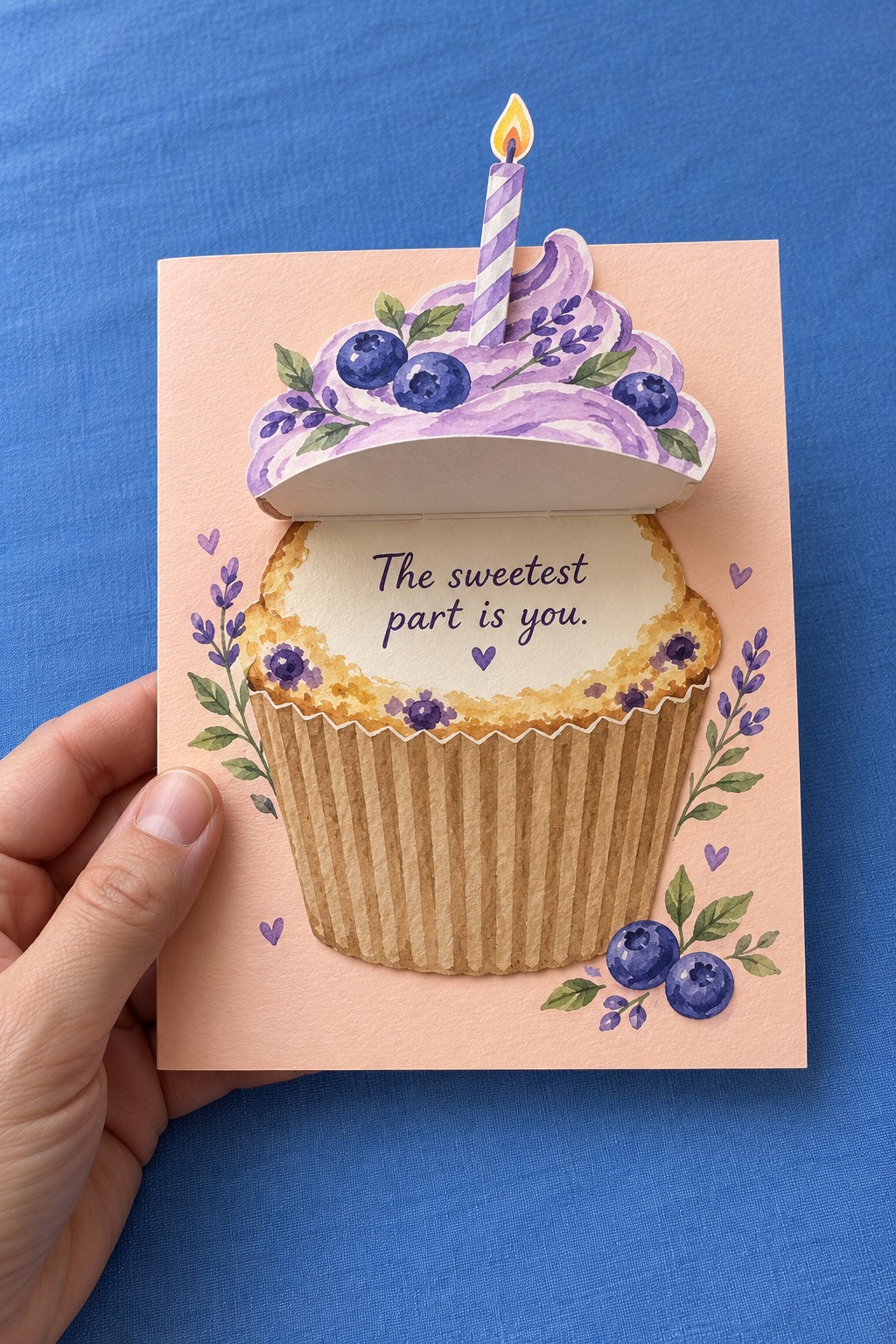 Pink card with a blueberry cupcake whose purple frosting flap lifts to reveal a birthday message