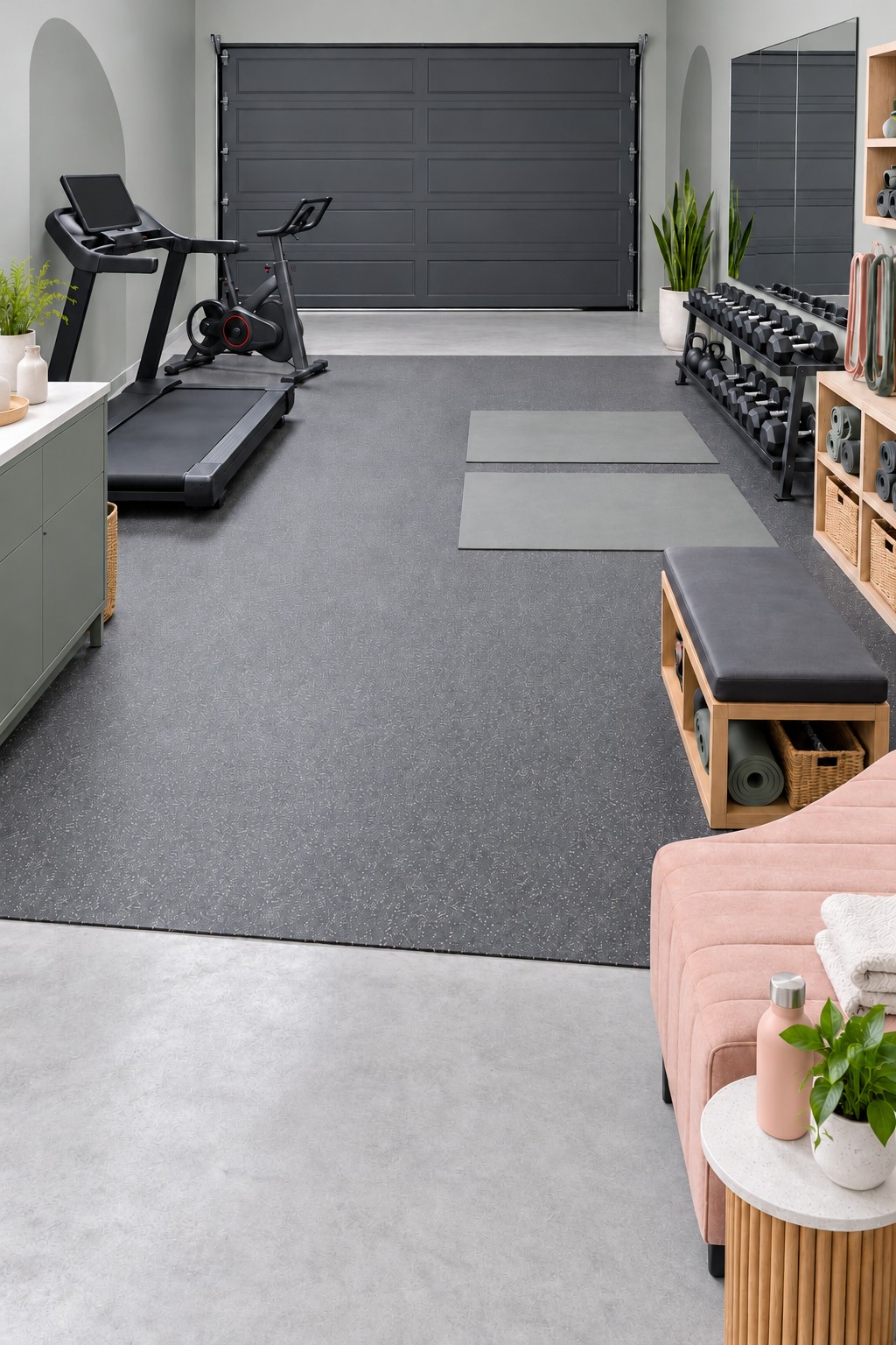 Garage gym with a treadmill, exercise bike, dumbbell rack, wall mirror, and open rubber floor area