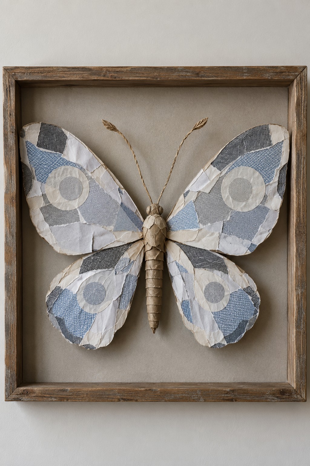 Blue gray and cream patchwork butterfly with a wrapped body inside a rustic wooden frame